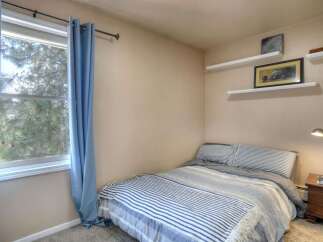 This cozy bedroom features a comfortable bed with a stylish striped comforter, perfect for a relaxing retreat.