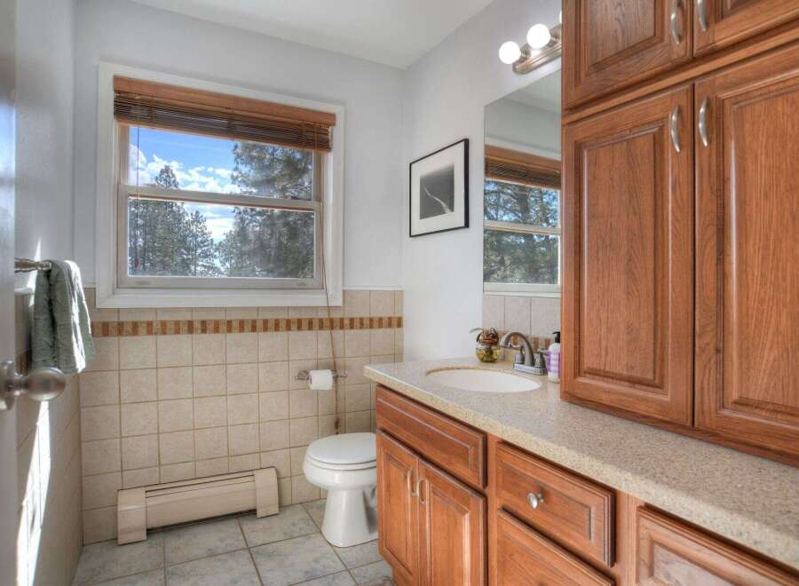 This beautiful bathroom features a bright and airy atmosphere with a large window that offers stunning views of the outdoors.