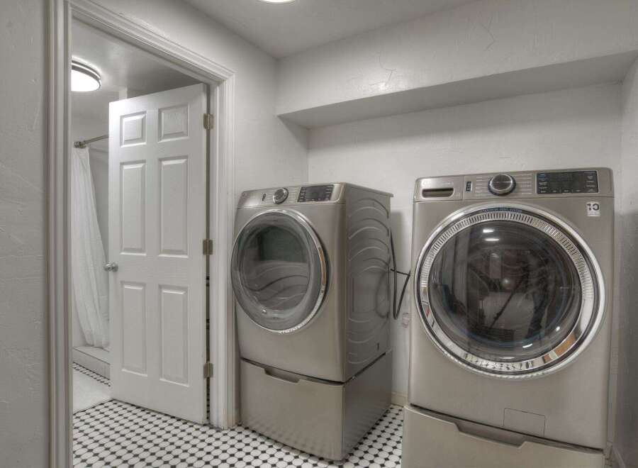 Step into this modern laundry room, featuring sleek, stainless steel appliances.