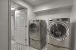Step into this modern laundry room, featuring sleek, stainless steel appliances.