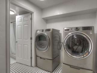 Step into this modern laundry room, featuring sleek, stainless steel appliances.
