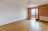 This bright and airy room features beautiful wooden floors and a stunning wooden accent wall.