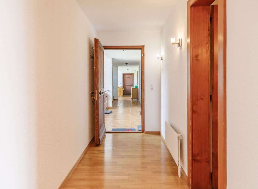 Step into this inviting hallway, showcasing beautiful hardwood floors and a warm, welcoming atmosphere.