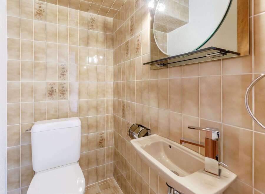 This bathroom features a unique design with beige tiles and floral accents.