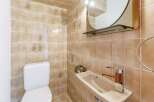 This bathroom features a unique design with beige tiles and floral accents.