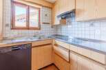 This charming kitchen features a warm, inviting design with wooden cabinetry and a stainless steel countertop.