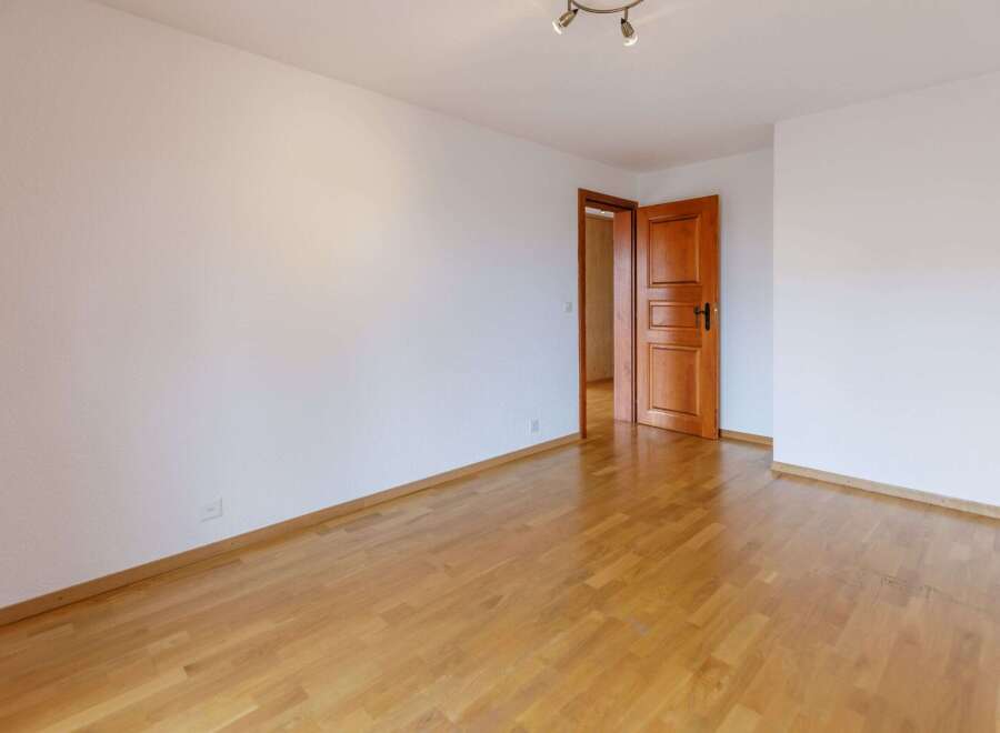 This inviting room features beautiful hardwood floors and crisp white walls, creating a bright and airy atmosphere.