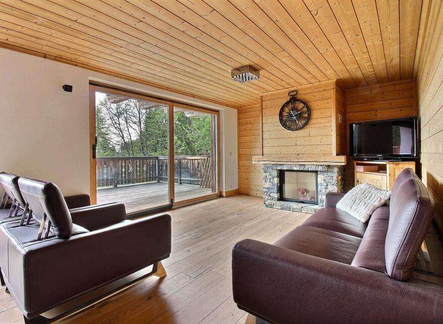 This cozy living room features a stunning wooden ceiling and floors, creating a warm and inviting atmosphere.