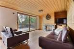This cozy living room features a stunning wooden ceiling and floors, creating a warm and inviting atmosphere.