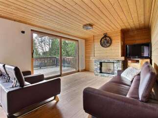 This cozy living room features a stunning wooden ceiling and floors, creating a warm and inviting atmosphere.