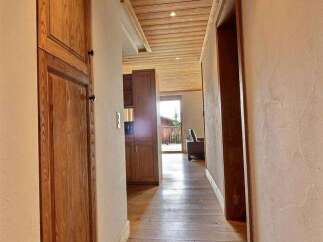 Step into this inviting hallway, showcasing beautiful wooden floors and a warm, natural aesthetic.