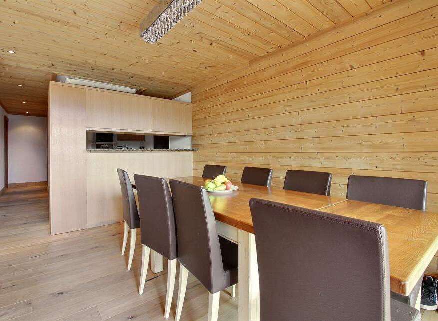 This stunning dining area features a beautiful wooden table and comfortable leather chairs, perfect for hosting gatherings.