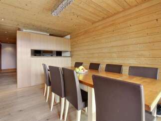 This stunning dining area features a beautiful wooden table and comfortable leather chairs, perfect for hosting gatherings.