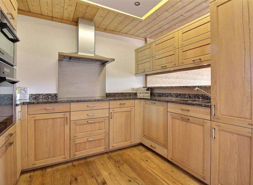 This stunning kitchen boasts custom cabinetry, offering ample storage and a warm, inviting atmosphere.
