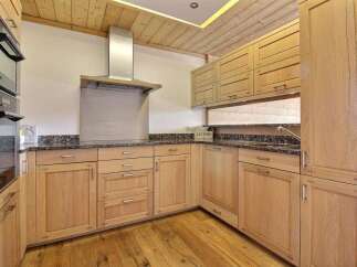 This stunning kitchen boasts custom cabinetry, offering ample storage and a warm, inviting atmosphere.