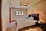 This cozy bedroom features a warm, inviting atmosphere with its wooden walls and ceiling.