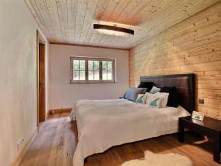 This cozy bedroom features a warm, inviting atmosphere with its wooden walls and ceiling.