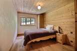 This cozy bedroom features a rustic design with wooden walls and flooring, creating a warm and inviting atmosphere.