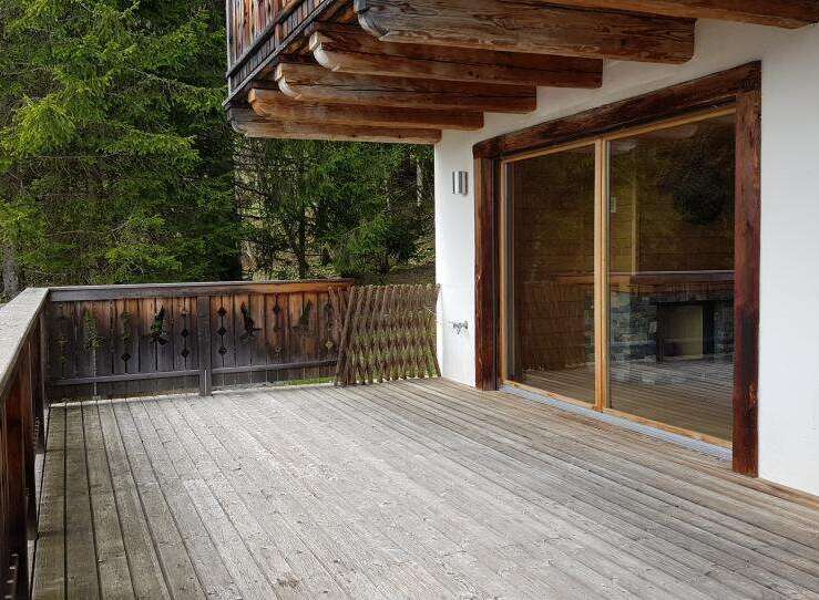 Enjoy the tranquility of this stunning property with a spacious wooden deck, perfect for outdoor relaxation.