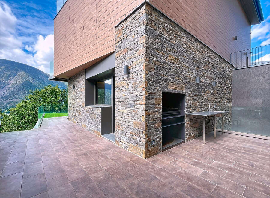 Discover modern luxury in this stunning property featuring a unique stone facade and a beautifully designed outdoor space.