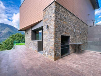 Discover modern luxury in this stunning property featuring a unique stone facade and a beautifully designed outdoor space.