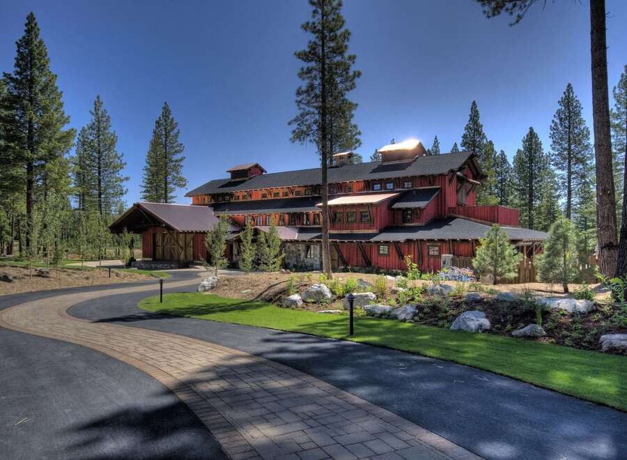 This stunning property boasts a unique architectural design, featuring a striking red exterior and a multi-level structure.