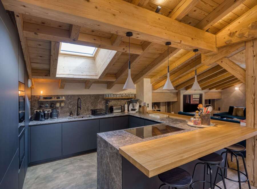This stunning kitchen boasts a rustic charm with its exposed wooden beams and a skylight that floods the space with natural light.