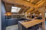 This stunning kitchen boasts a rustic charm with its exposed wooden beams and a skylight that floods the space with natural light.