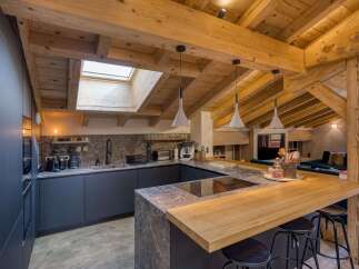 This stunning kitchen boasts a rustic charm with its exposed wooden beams and a skylight that floods the space with natural light.