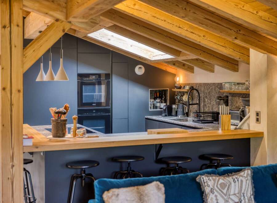 This stunning kitchen boasts a modern design with a touch of rustic charm, featuring exposed wooden beams and sleek cabinetry.