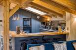 This stunning kitchen boasts a modern design with a touch of rustic charm, featuring exposed wooden beams and sleek cabinetry.