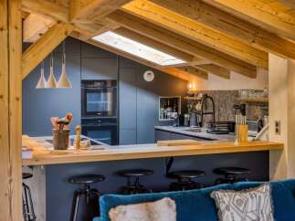 This stunning kitchen boasts a modern design with a touch of rustic charm, featuring exposed wooden beams and sleek cabinetry.