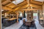 Experience luxury living in this stunning chalet, featuring a warm and inviting interior with exposed wooden beams and a cozy fireplace.