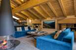 This luxurious living space features a stunning modern fireplace and a cozy blue velvet sofa, perfect for relaxing.