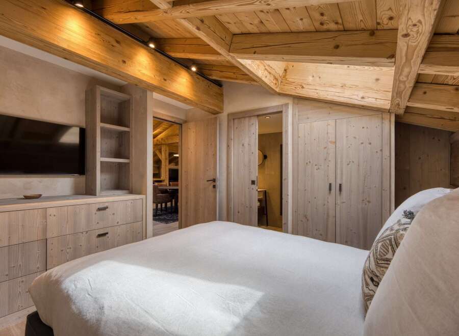 Experience rustic elegance in this stunning bedroom, featuring exposed wooden beams and custom cabinetry.