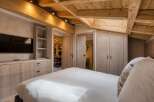 Experience rustic elegance in this stunning bedroom, featuring exposed wooden beams and custom cabinetry.