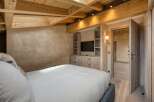 This luxurious bedroom boasts a stunning wooden ceiling and walls, creating a warm and inviting atmosphere.