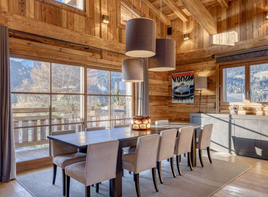 Experience the warmth of this stunning dining room, featuring exquisite wooden paneling and a captivating view.
