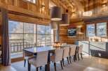 Experience the warmth of this stunning dining room, featuring exquisite wooden paneling and a captivating view.