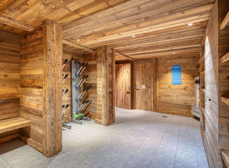 Step into a luxurious ski storage room, designed with natural wood paneling and a modern ski boot drying system.
