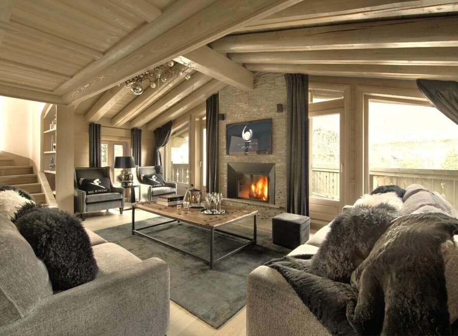 Experience luxury living in this stunning chalet, featuring a cozy fireplace and a stylish living area.