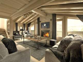 Experience luxury living in this stunning chalet, featuring a cozy fireplace and a stylish living area.
