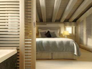 This cozy bedroom features a rustic design with exposed wooden beams and a light-filled ambiance.