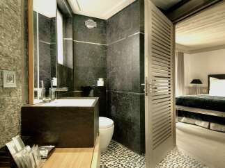 Step into luxury with this stunning bathroom, featuring sleek dark stone tiles and a modern design.