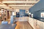 This stunning kitchen showcases a rustic design with wooden cabinetry and a matching ceiling, creating a warm and inviting atmosphere.