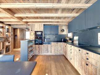 This stunning kitchen showcases a rustic design with wooden cabinetry and a matching ceiling, creating a warm and inviting atmosphere.
