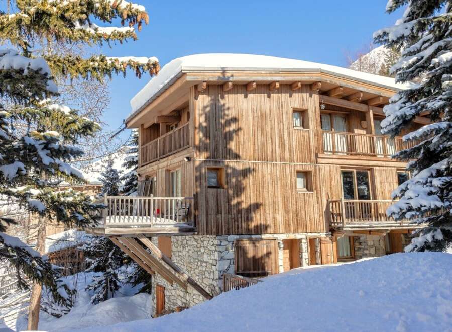 This stunning wooden chalet offers a luxurious retreat in a snowy paradise.