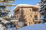 This stunning wooden chalet offers a luxurious retreat in a snowy paradise.