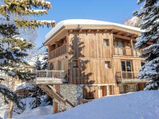 This stunning wooden chalet offers a luxurious retreat in a snowy paradise.