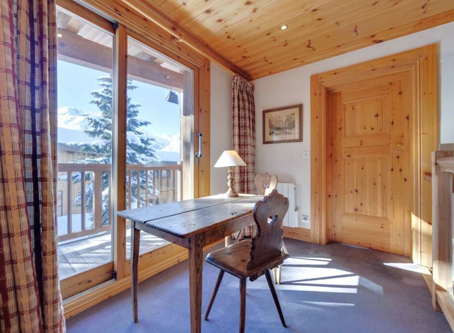 This charming property boasts a cozy study area with a rustic wooden desk and chair, perfect for work or relaxation.